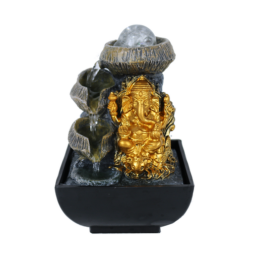 A golden Ganesha statue with a serene water feature behind it, set on a black base which appears to be the fountain's base.