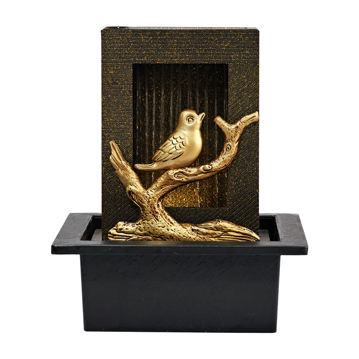 A gold-colored bird fountain with a bird design perched on a branch, set in a black square-shaped base.