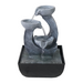 A modern Zen-inspired water feature with a minimalist design, consisting of two stylized pots made of a dark material, with water flowing from one pot to the other.