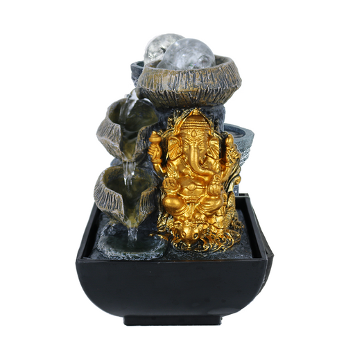 A black pottery tower with a gold-colored statue of a Hindu deity, with water flowing over the edge.