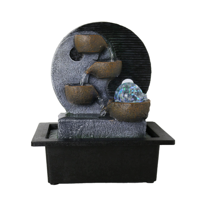 Decorative water fountain with three stone-like bowls and a glowing ball on a white background