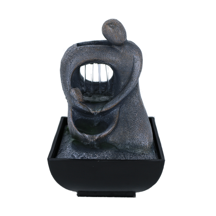A Zen-inspired water feature with a figure that resembles a person's upper body and head, with water flowing down their back into a black basin.