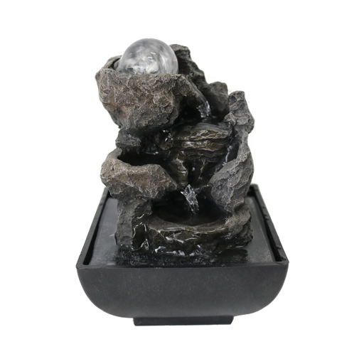 Decorative rock fountain with a light on a white background